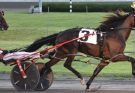 Harness driver Jason Bartlett racing towards the finish line at Yonkers raceway.